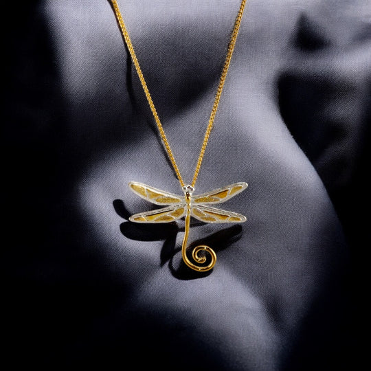 RossJewelrys necklace with white-gold dragonfly and white-gold chain on fabric backdrop.

