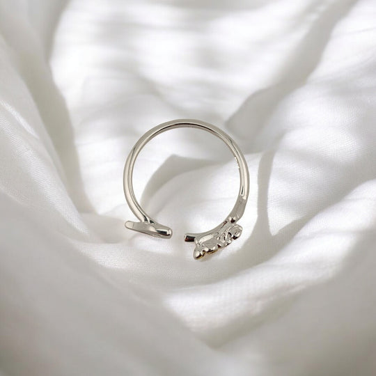 Top angle of silver ring with bird figure and flower accents