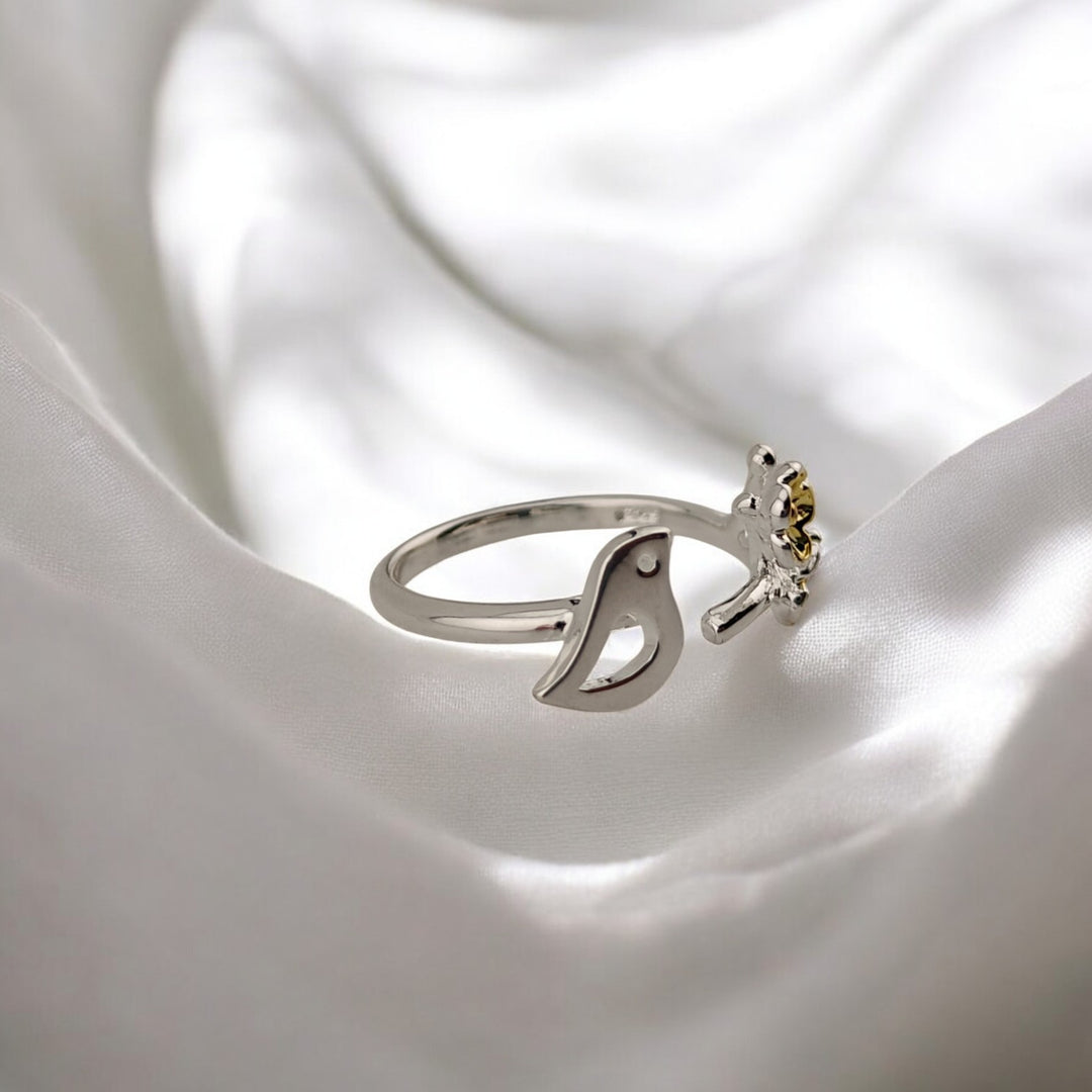 
Side view showing bird and gold flower design on polished silver ring