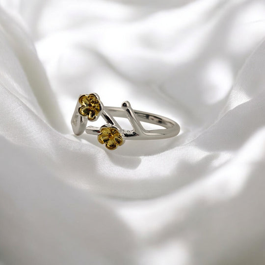 Close-up of bird and flowers on adjustable silver ring