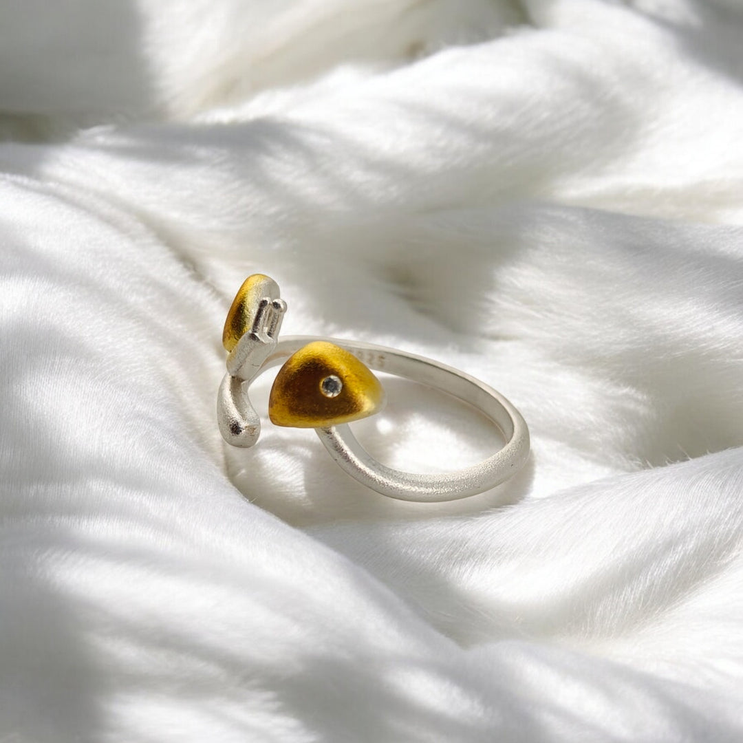 Macro side angle of yellow snail ring resting on white fur-like surface
