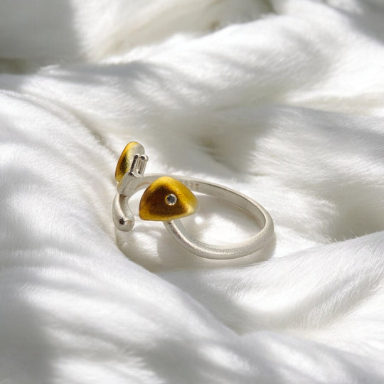Macro side angle of yellow snail ring resting on white fur-like surface
