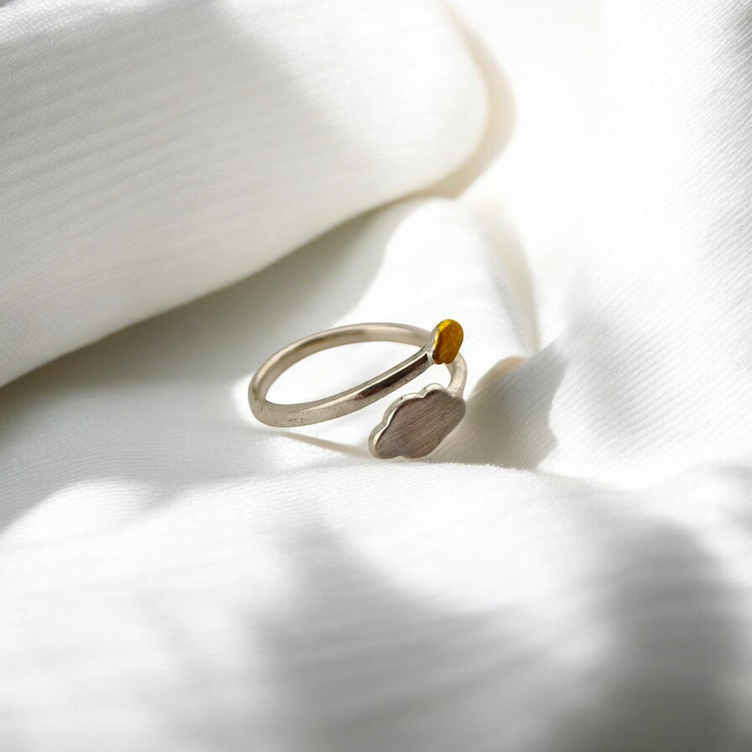 Back view of silver ring resting on soft fabric folds
