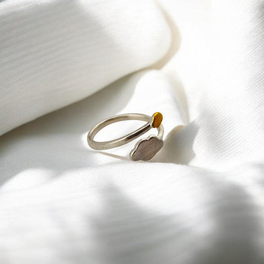 Back view of silver ring resting on soft fabric folds