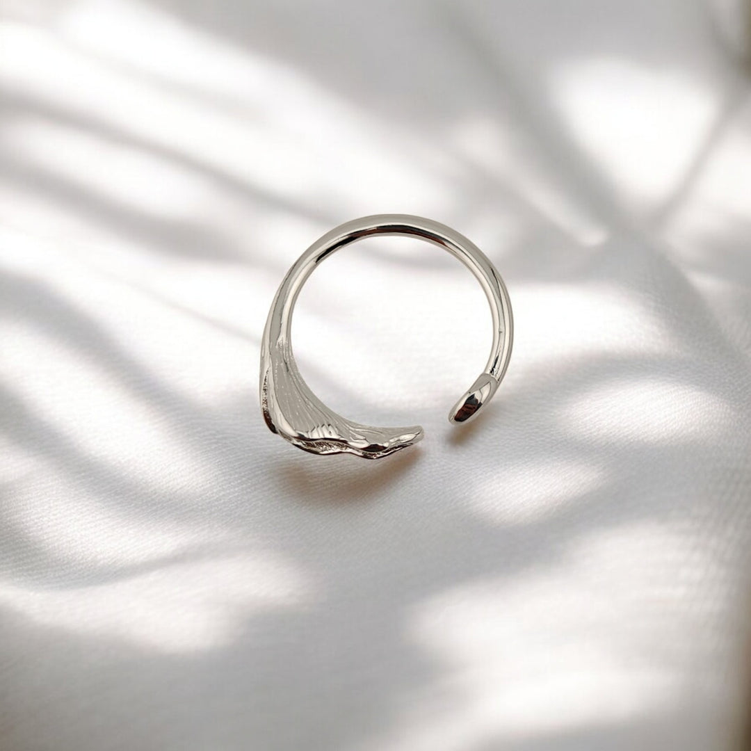 Top view of botanical silver ring with single calla bloom and swirl end