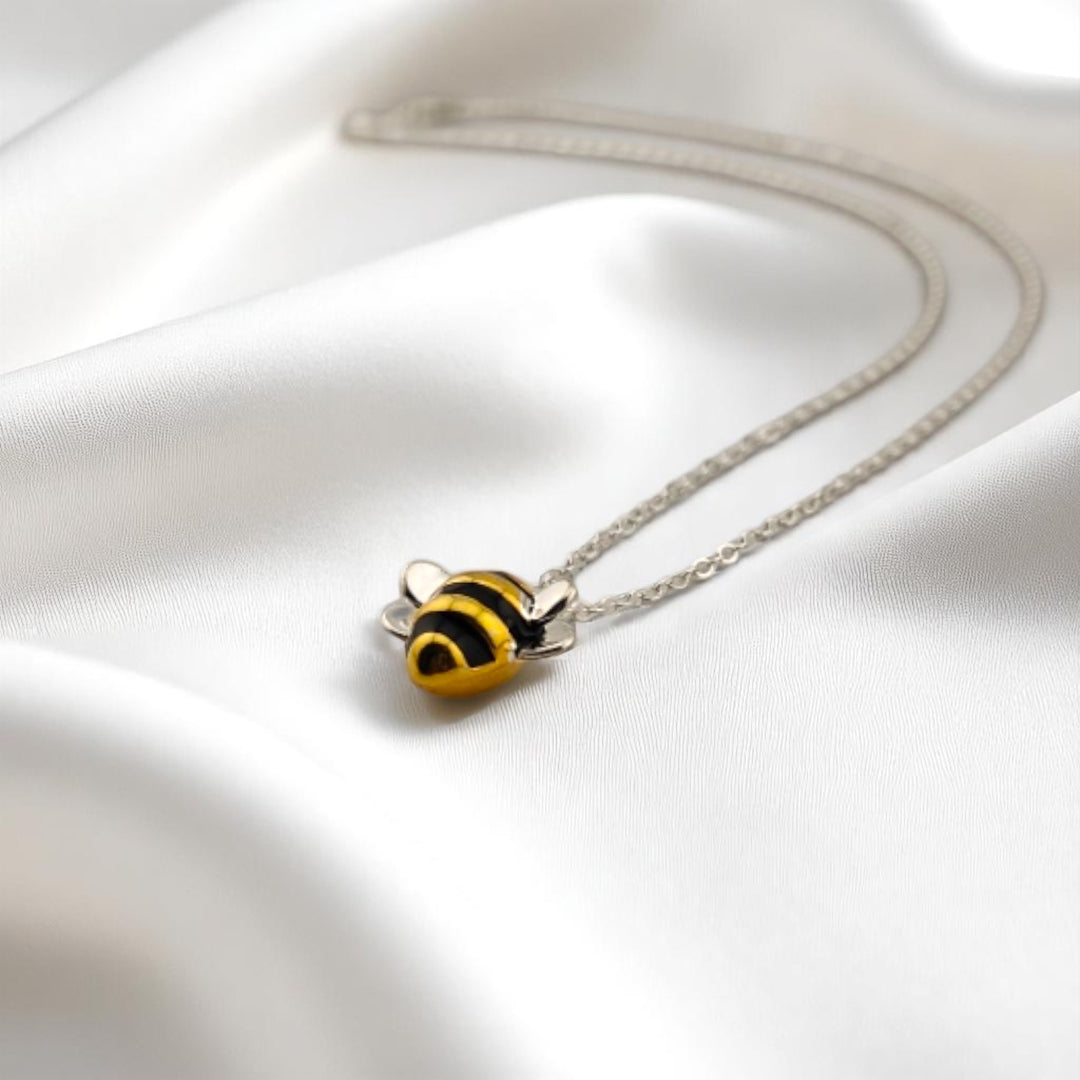 ellow bee charm necklace on silver chain with natural light