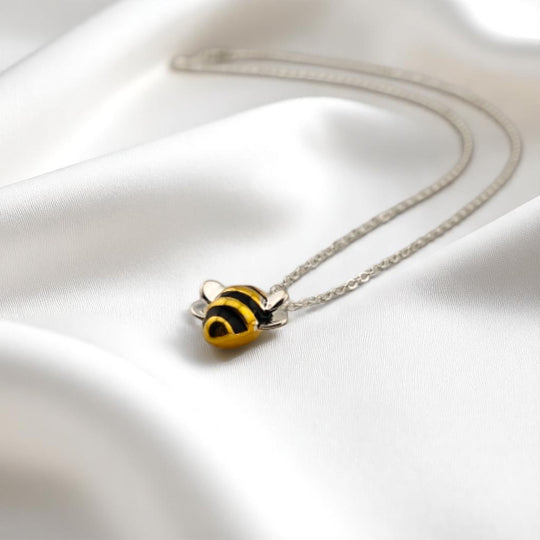 ellow bee charm necklace on silver chain with natural light