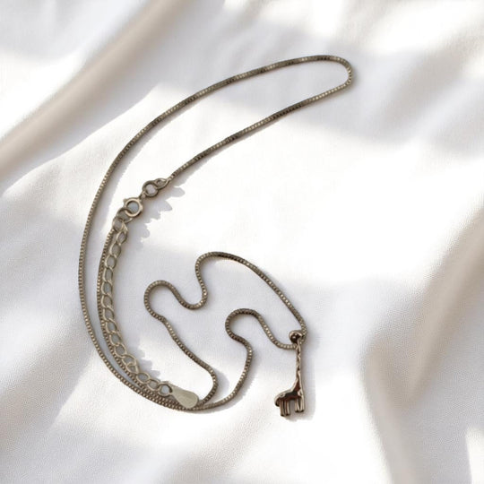 Giraffe silhouette pendant necklace on soft fabric