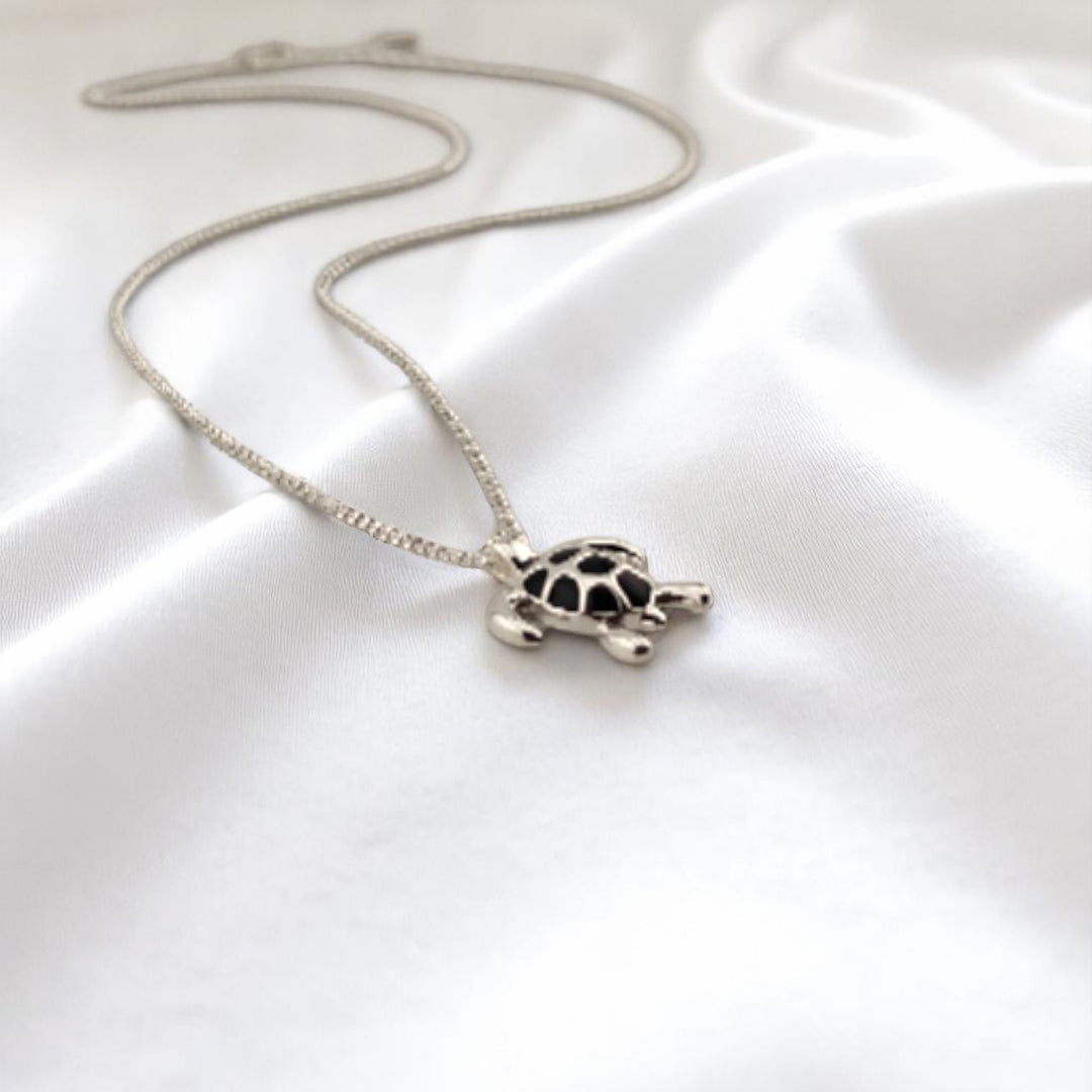 Side view of turtle pendant showing its 3D shape