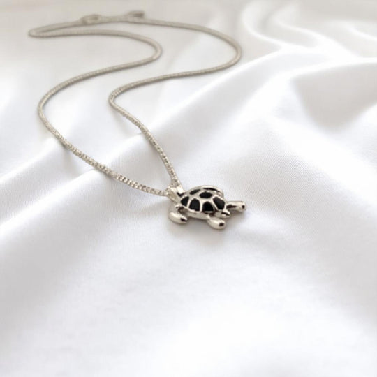 Side view of turtle pendant showing its 3D shape