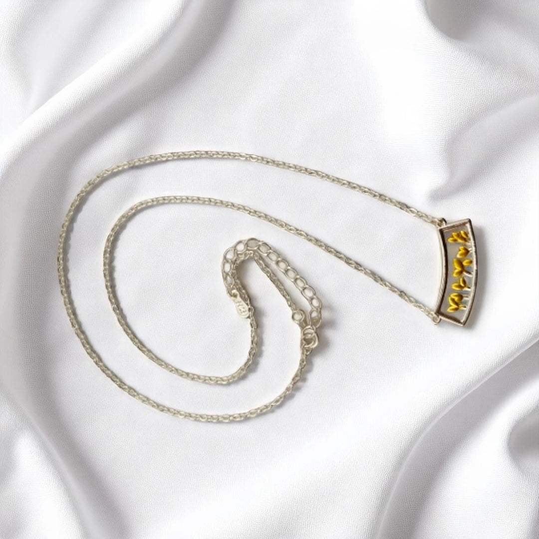 Eco-conscious necklace with sprouting yellow leaves in a curve