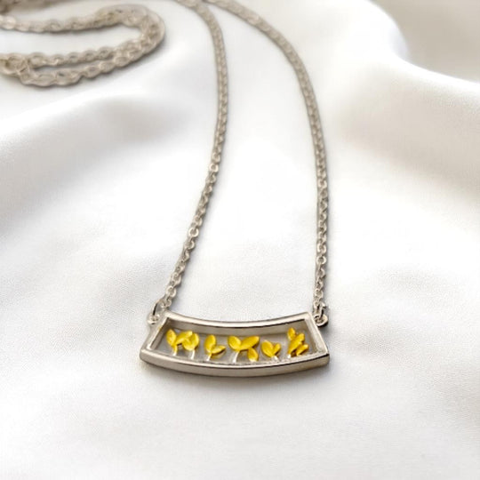 Leaf sprout pendant necklace with silver chain on satin fabric
