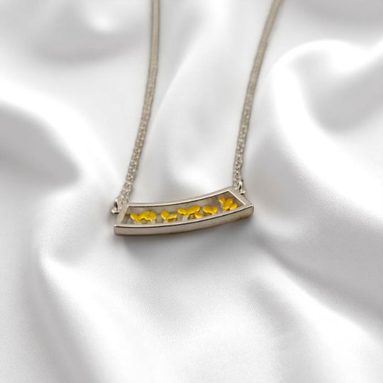 Nature-inspired necklace featuring yellow leaves in silver frame
