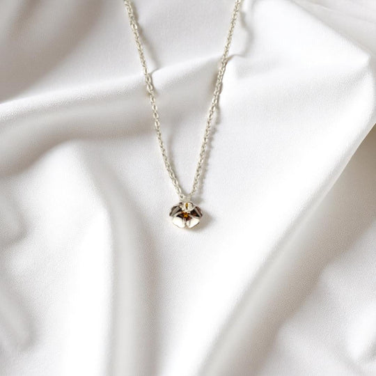 Close-up of nature-inspired pansy necklace laid flat