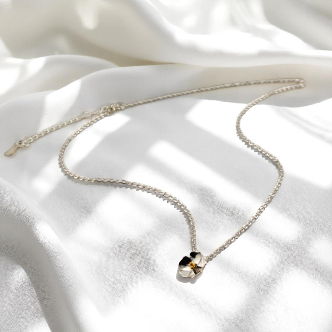 Pansy flower pendant necklace with silver chain displayed in a loop