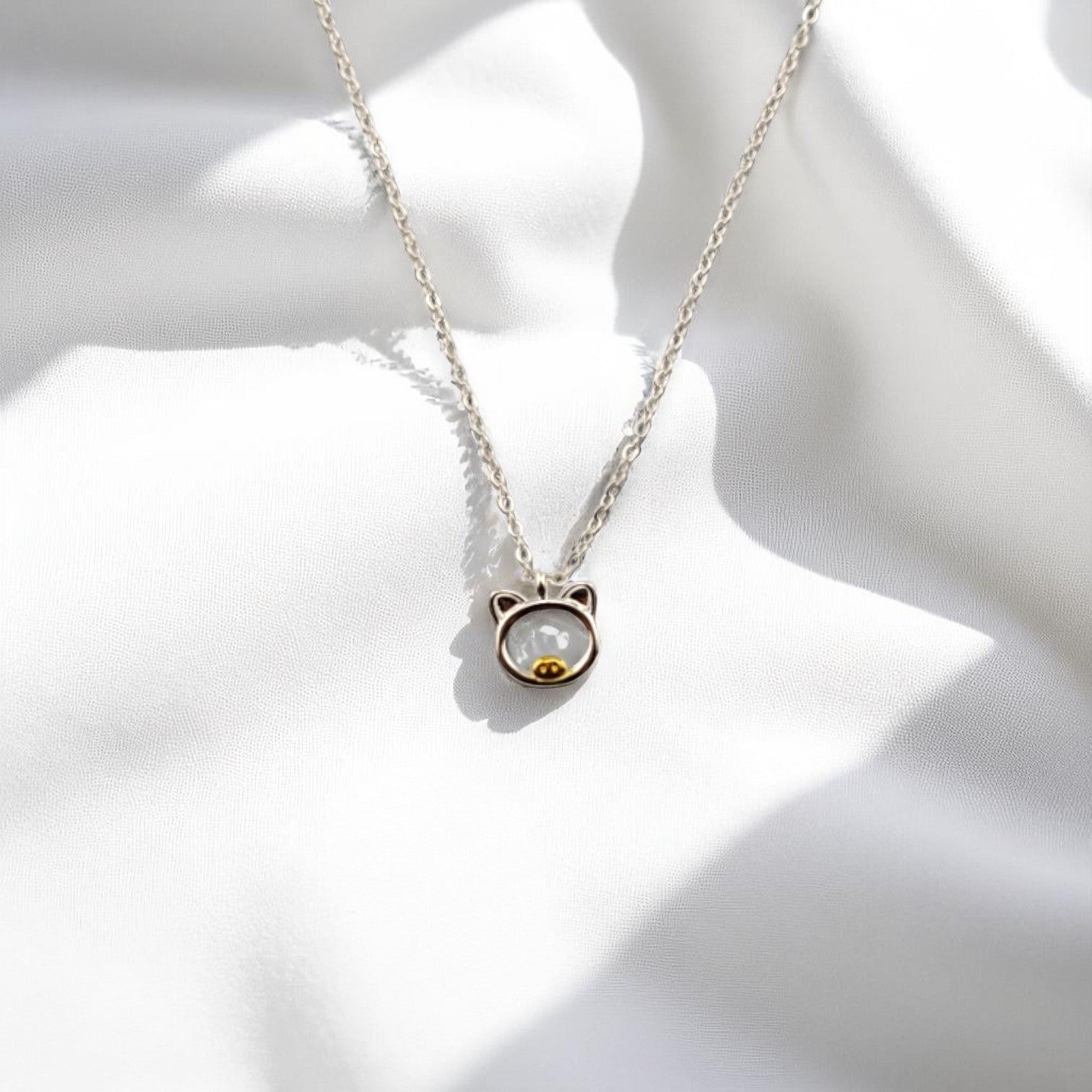 Front view of the pig-shaped necklace on soft white background