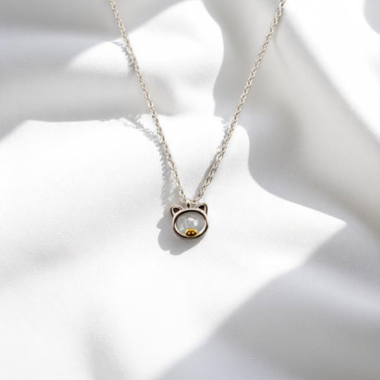 Front view of the pig-shaped necklace on soft white background