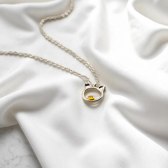 Angled view of silver pig necklace highlighting the shiny finish
