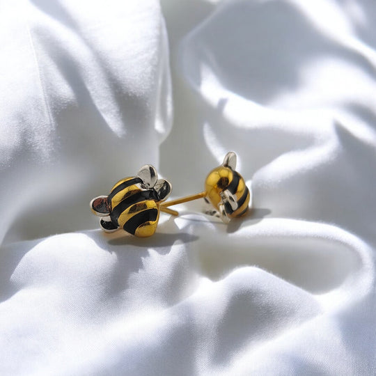 Side angle of golden bee earrings with silver wings