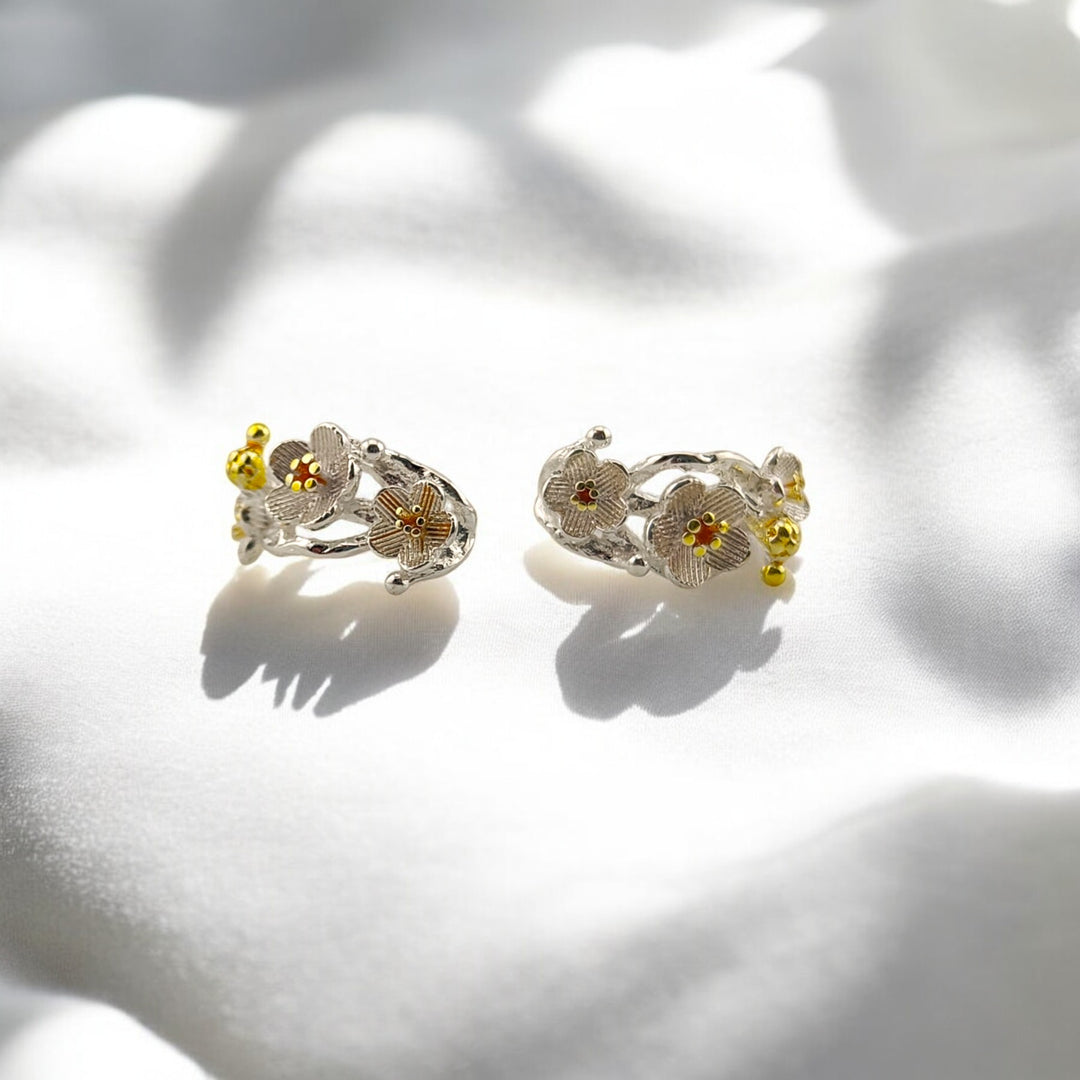  Close-up of earrings' delicate flower design with orange centers