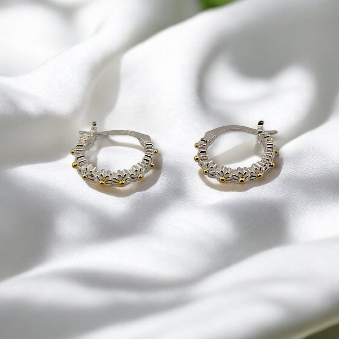 Floral hoop earrings with visible petal engravings and curved open view