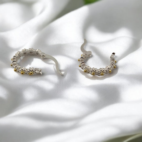 Nature-inspired hoop earrings with daisy pattern shown closed