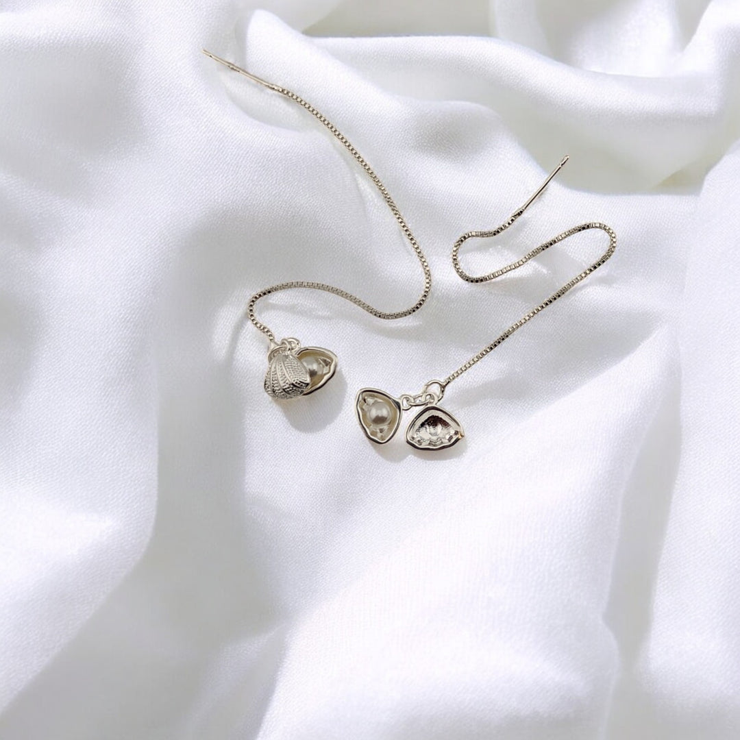  Full view of nature-inspired seashell threader earrings on fabric