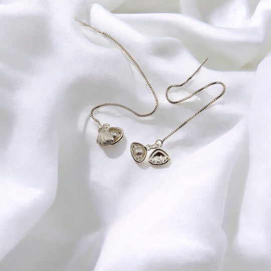  Full view of nature-inspired seashell threader earrings on fabric