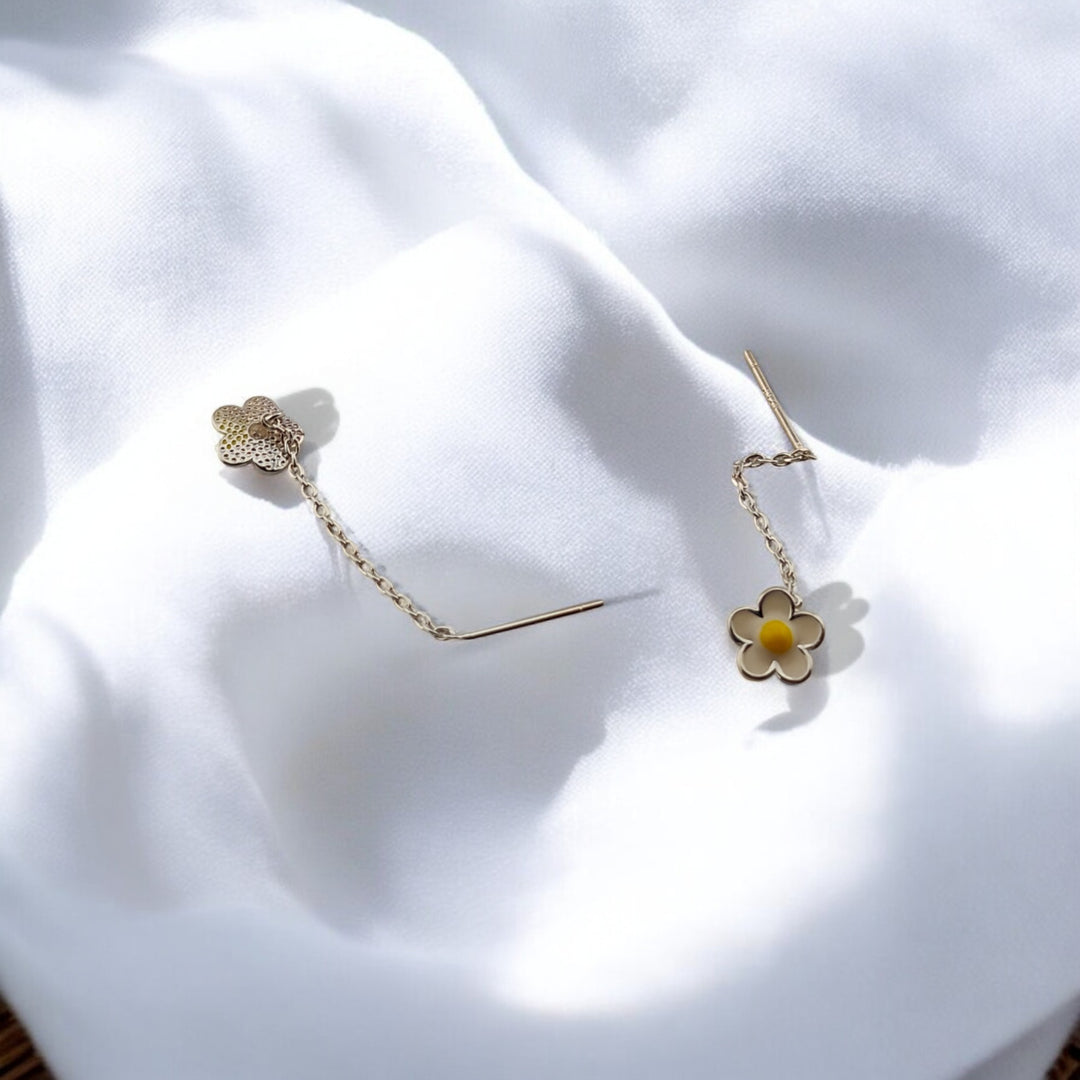Backside view of daisy chain earrings showing petal texture and threading pin, displayed on a clean white surface.

