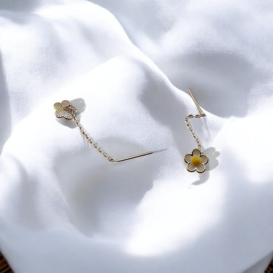 Backside view of daisy chain earrings showing petal texture and threading pin, displayed on a clean white surface.

