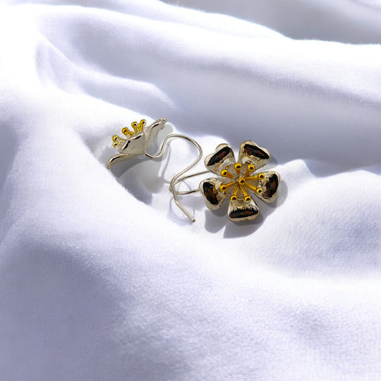  Close-up of one floral earring facing up, showing petal texture and golden center