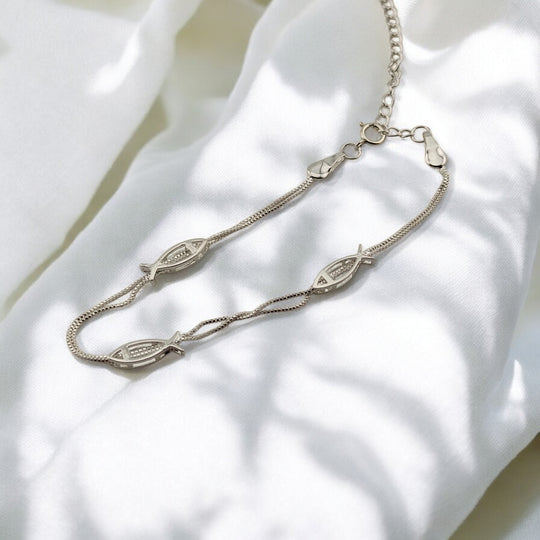 Close-up of silver fish link design on bracelet, ocean-inspired style