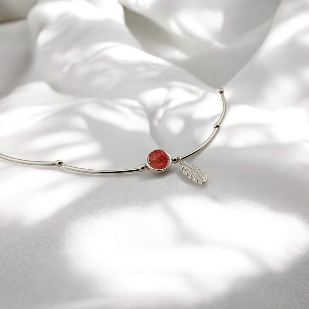 Minimal silver bracelet with nature-inspired feather and red gem