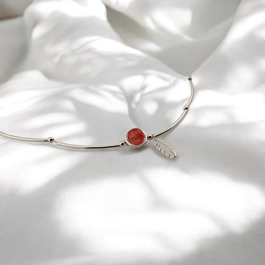 Minimal silver bracelet with nature-inspired feather and red gem