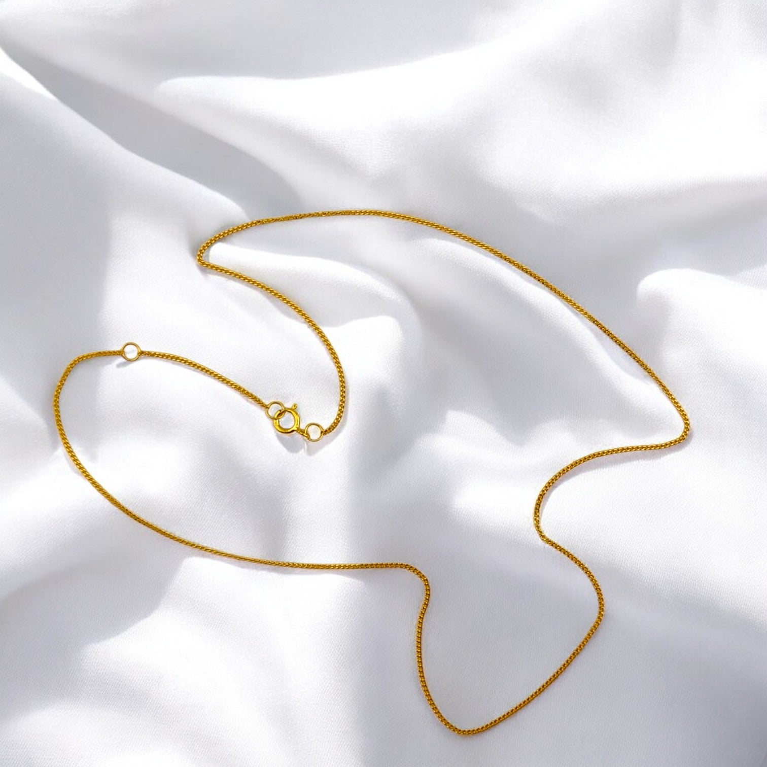 Elegant 925 silver necklace with 18k gold plating, displayed in a curved shape on white fabric – minimalist chain by RossJewelrys.
