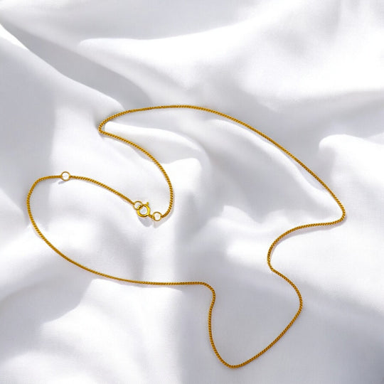 Elegant 925 silver necklace with 18k gold plating, displayed in a curved shape on white fabric – minimalist chain by RossJewelrys.