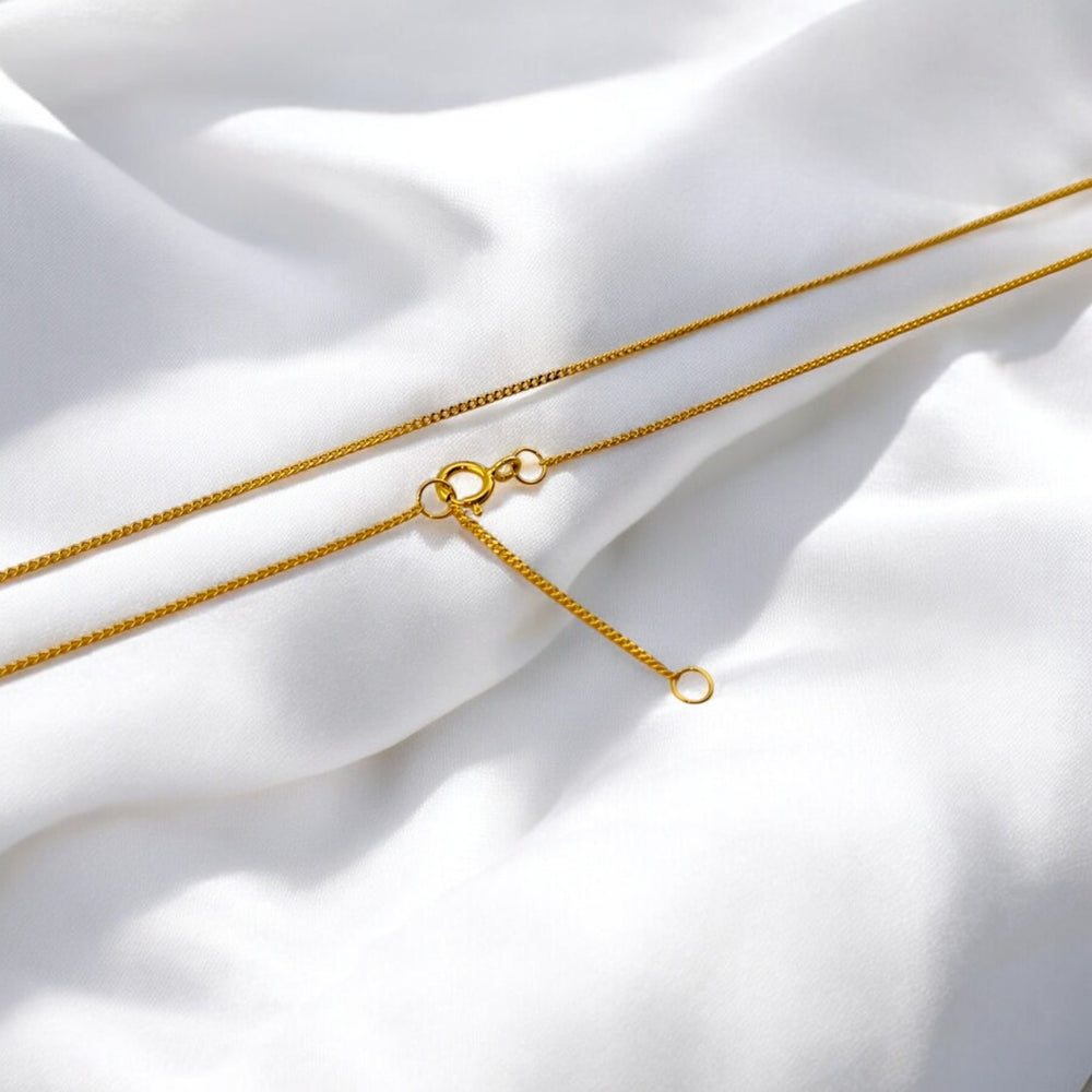 Delicate gold-plated 925 silver chain necklace from RossJewelrys, laid flat on soft white fabric with clasp detail visible.
