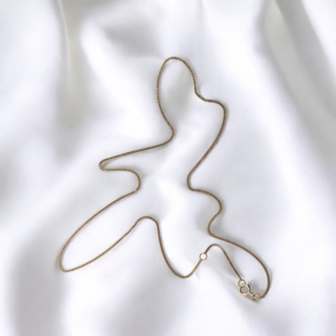 Close-up of 925 silver box chain necklace on white fabric with spring ring clasp – elegant minimalist jewelry by RossJewelrys.

