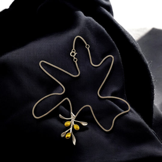 Gold-plated olive branch necklace on a black fabric background – RossJewelrys
