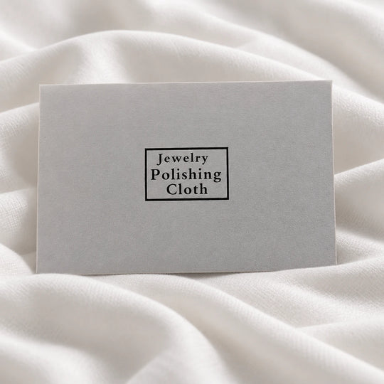 Closed paper envelope labeled Jewelry Polishing Cloth on white fabric