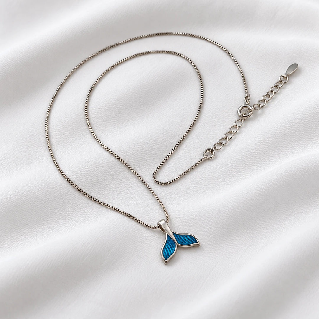 Close view of the blue dolphin tail pendant with textured fin lines and necklace chain