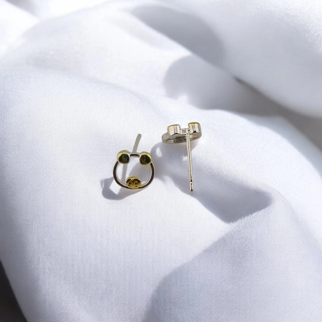 Pig stud earrings showing one front-facing design and one post and backing