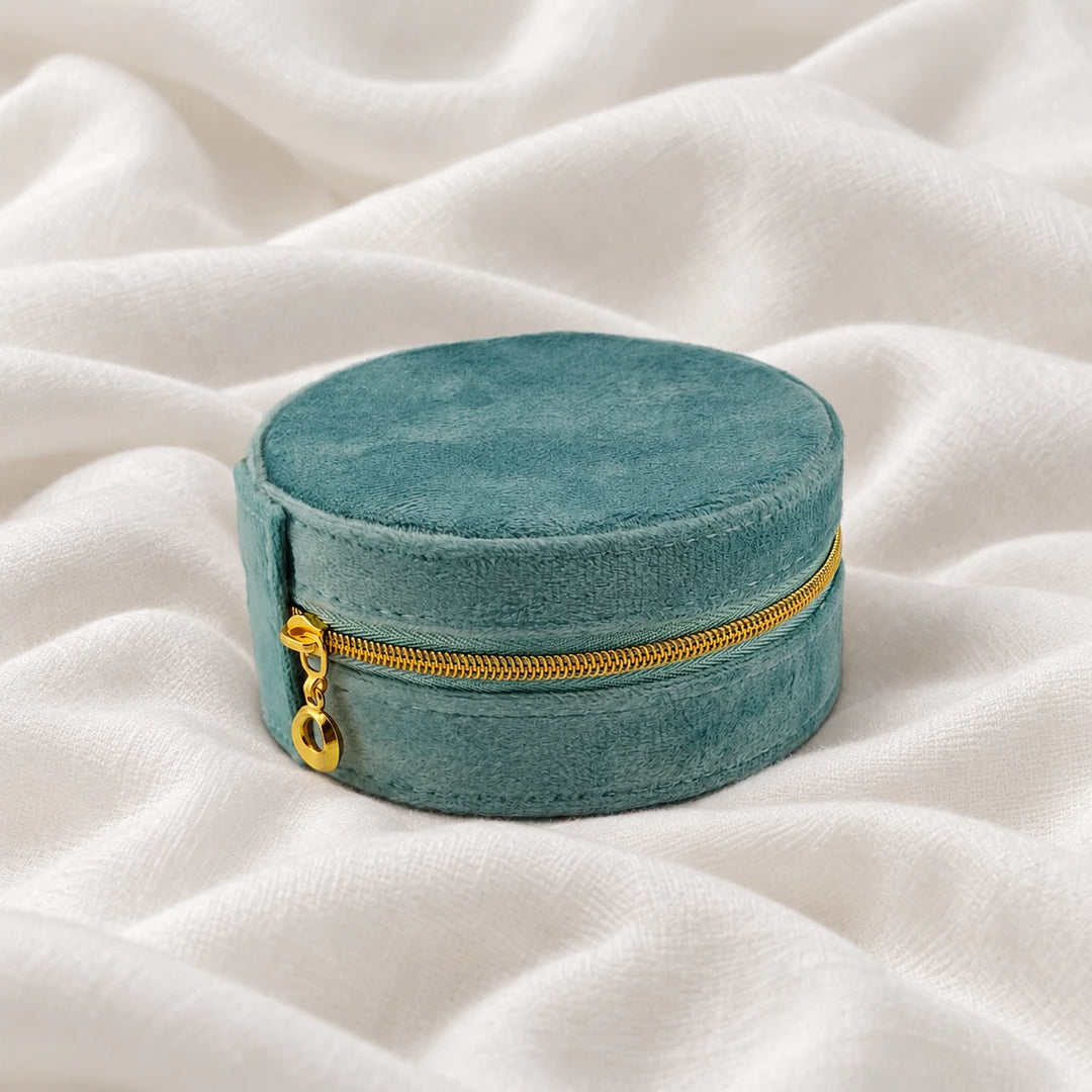 Closed teal velvet travel jewelry case with a gold-tone zipper