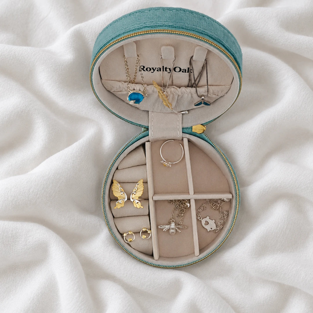 Overhead view of an open teal jewelry case holding necklaces, rings and earrings