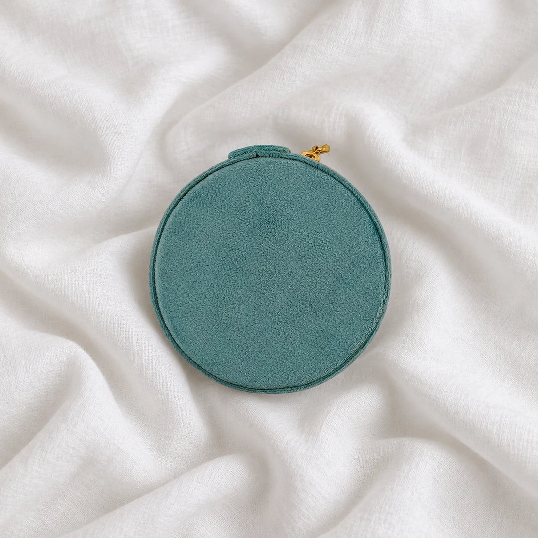 Top view of the round teal velvet travel jewelry case