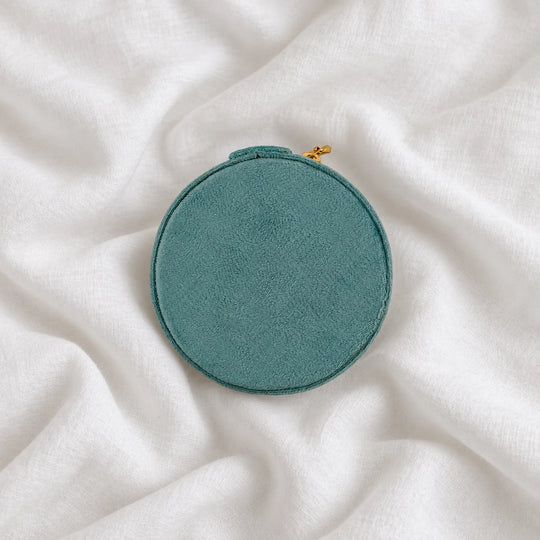 Top view of the round teal velvet travel jewelry case