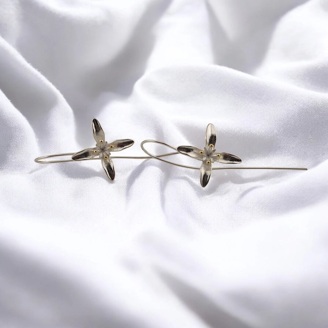 Pair of trumpet flower earrings with silver-tone petals and gold-tone center details