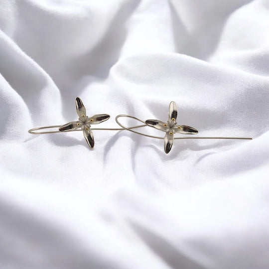 Pair of trumpet flower earrings with silver-tone petals and gold-tone center details